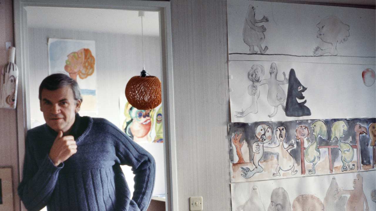 a man in a sweater leaning along a doorway